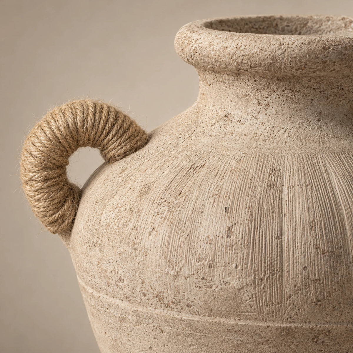 Close view of a tan wrapped round handle and vertically grooved weathered ceramic shoulder