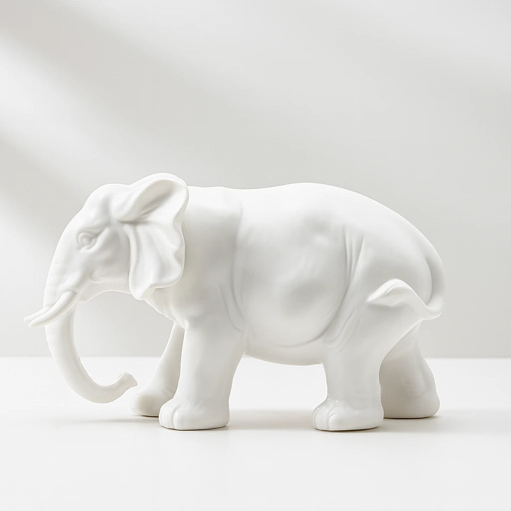 White ceramic elephant figurine on a light gray background