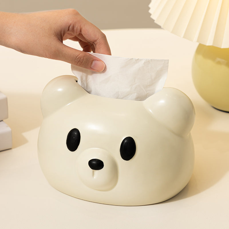 White bear-shaped tissue box on a table with a calendar in the background