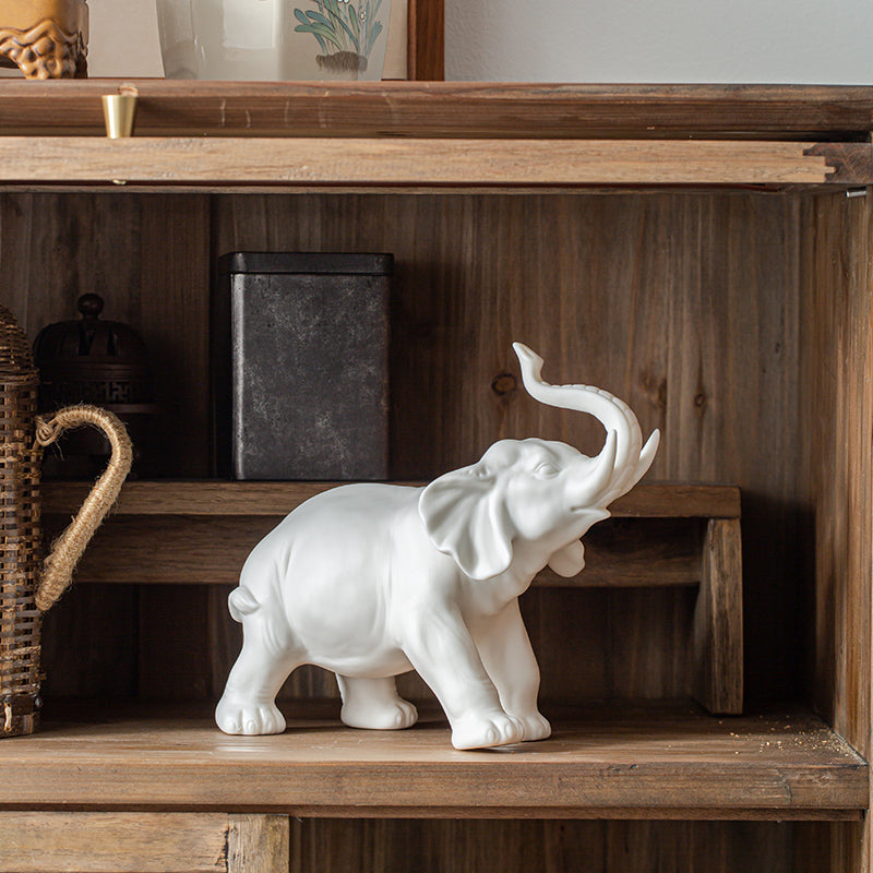 White elephant figurine on a wooden shelf