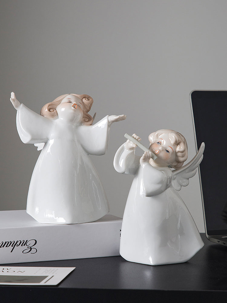 Two white angel figurines on a dark surface with a gray background