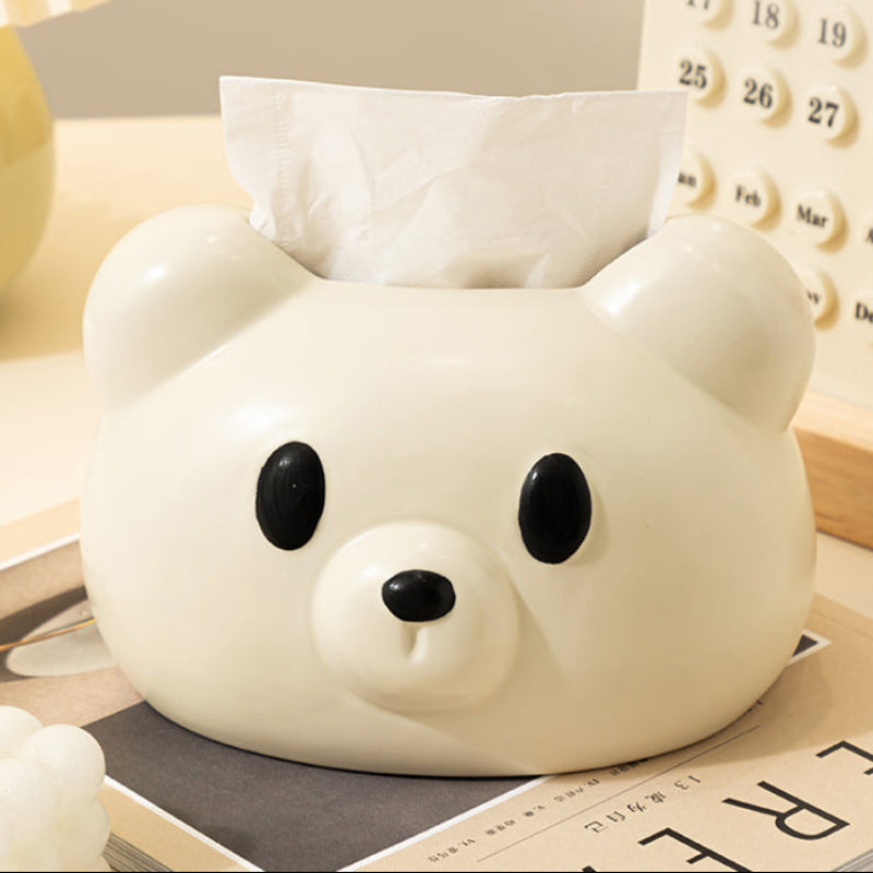 White bear-shaped tissue box on a table with a calendar in the background