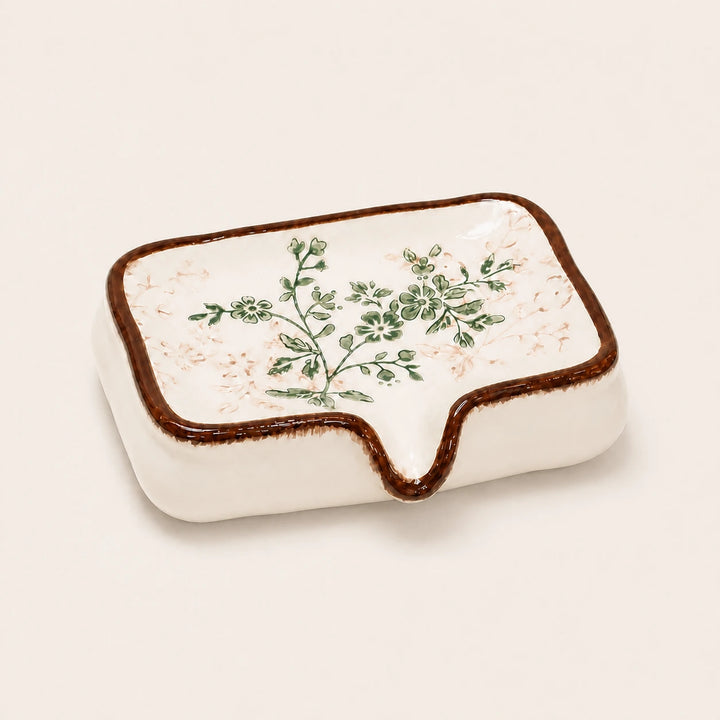 Vintage botanical ceramic soap dish on a warm ivory studio background