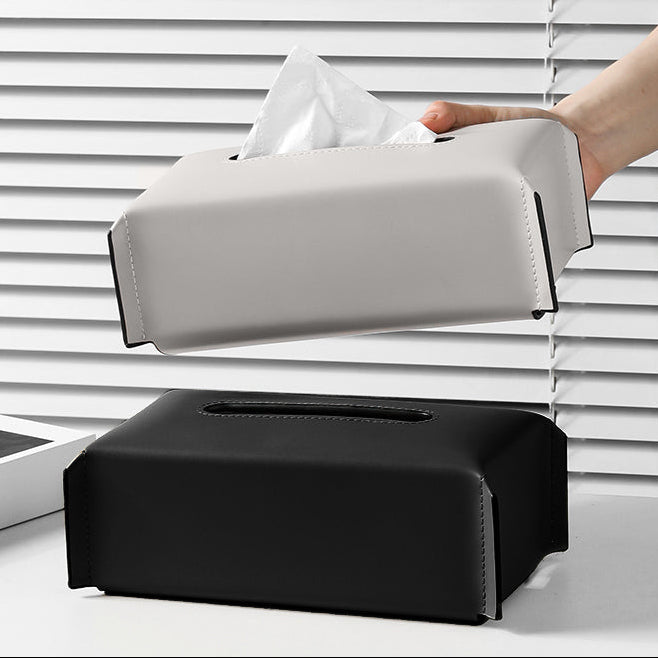 Modern tissue box cover with a hand pulling out tissues against a white background.