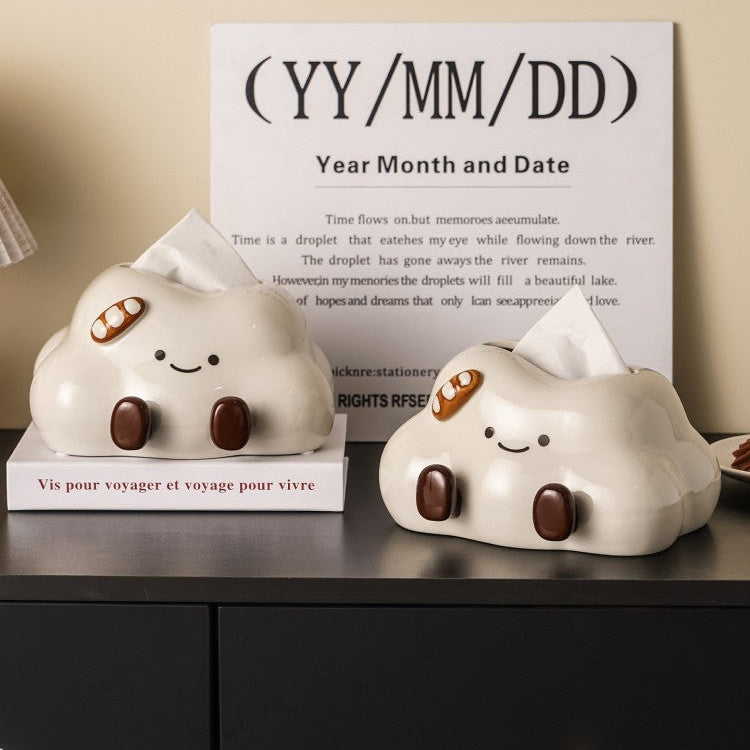 Two cloud-shaped tissue holders with cartoon faces on a shelf, with a sign displaying 'Year Month and Date' in the background.