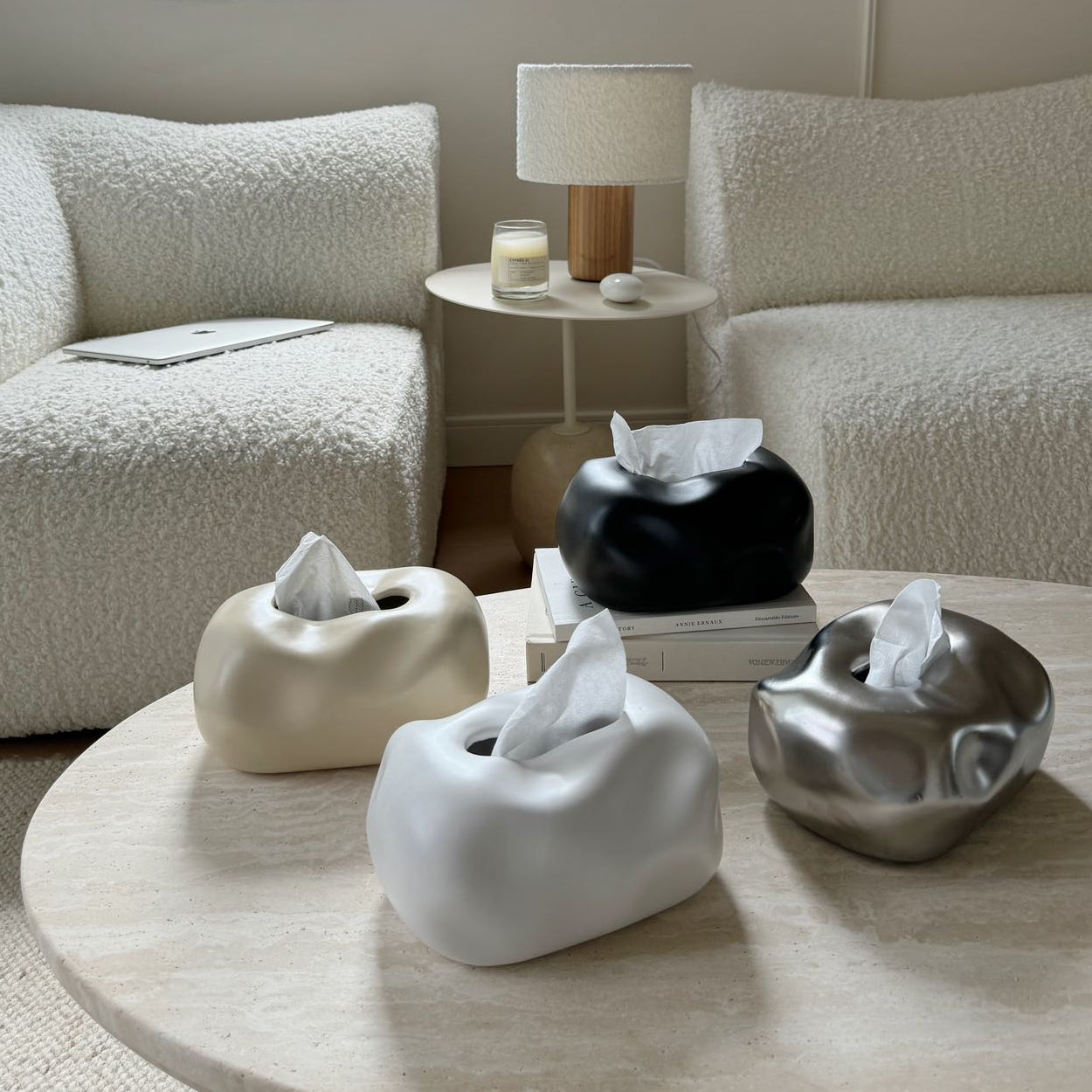 Decorative tissue holders on a coffee table in a living room setting.