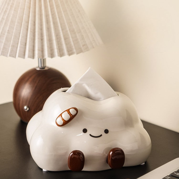 Cute cloud-shaped tissue holder on a desk with a person using a laptop.