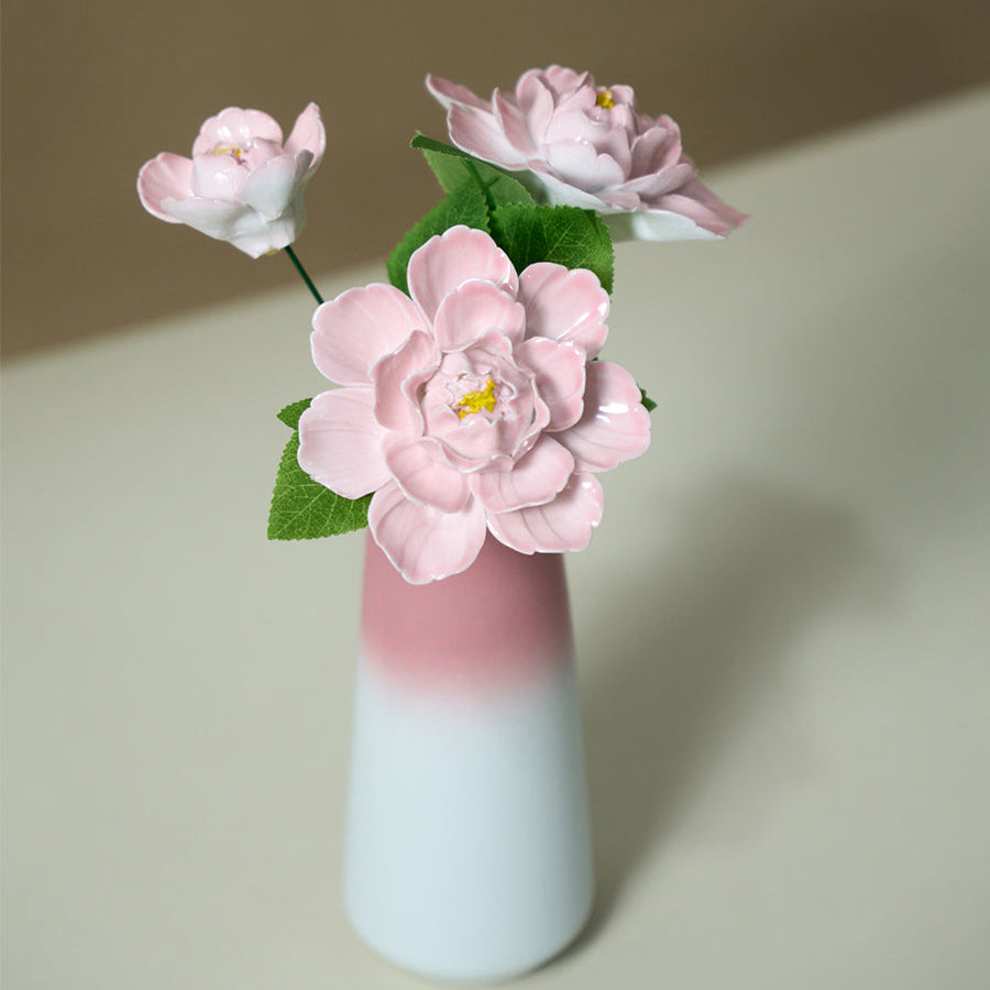Decorative vase with pink flowers on a neutral background