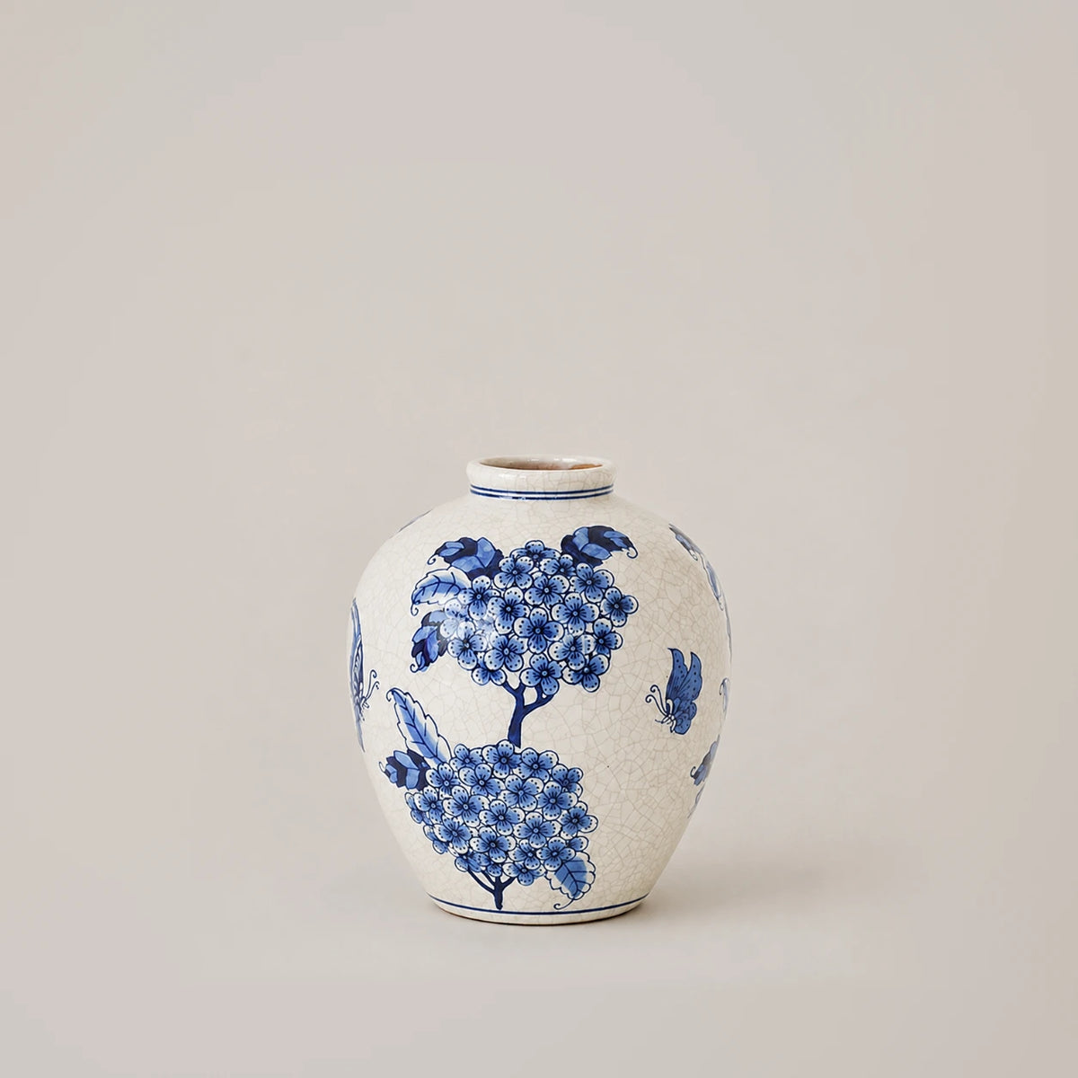 Small blue and white vase with two floral clusters and a butterfly on glossy crackle glaze.