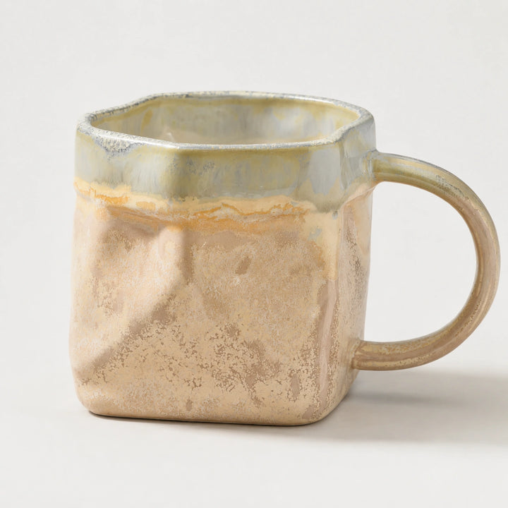 Cloud Mist faceted ceramic mug with pale reactive glaze, a gray-cream rim and a large curved handle.