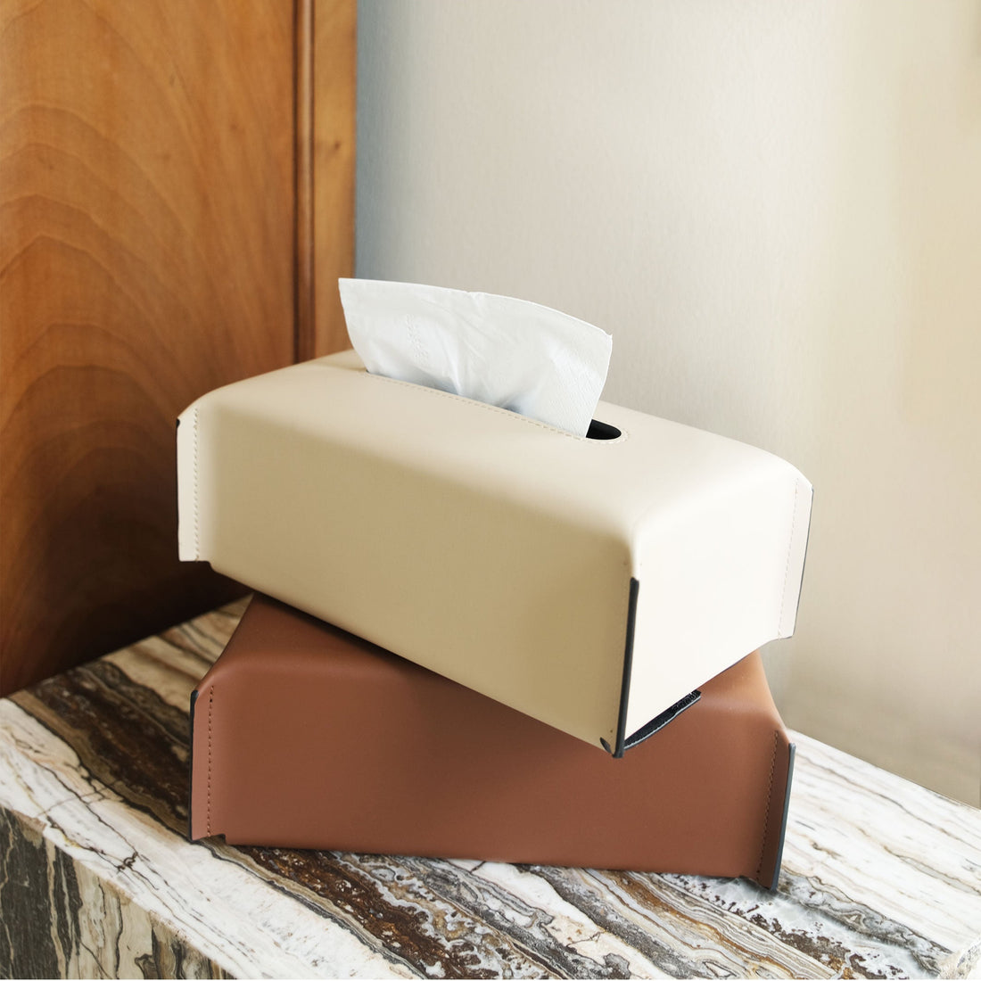 Tissue box on a marble surface with a wooden wall in the background