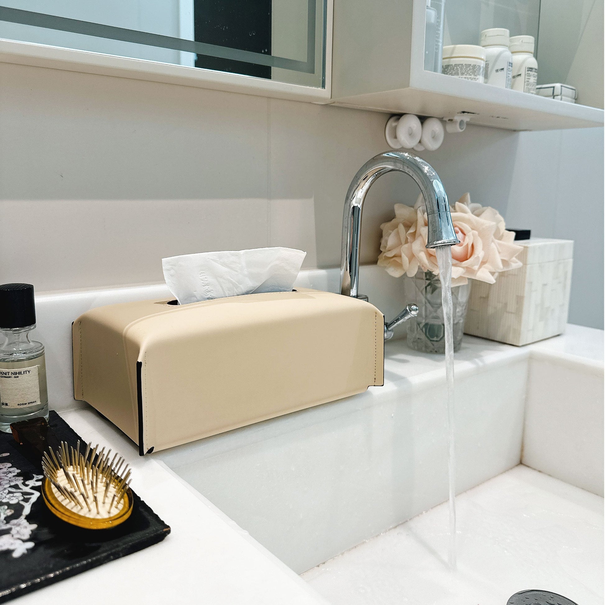 Beige tissue box on a bathroom counter with a sink and mirror in the background