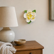 Small Ruffled Peony Ceramic Wall Flower in Golden Yellow Accent mounted above a small ceramic lamp in a guest room.