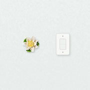 Medium Lotus Bloom Ceramic Wall Flower in Golden Yellow Accent beside a plain light-switch wall plate for scale.