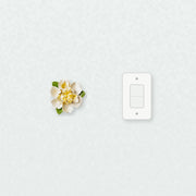 Medium Ruffled Peony Ceramic Wall Flower in Golden Yellow Accent beside a plain light-switch wall plate for scale.