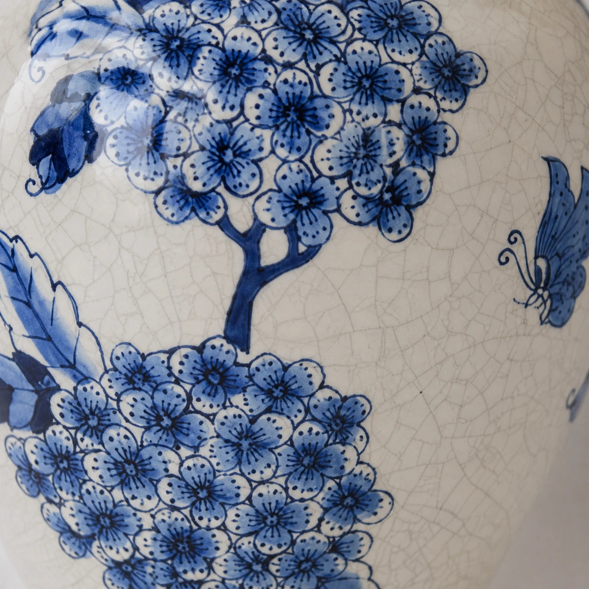 Close-up of blue floral brushwork and fine crackle lines on the small vase.