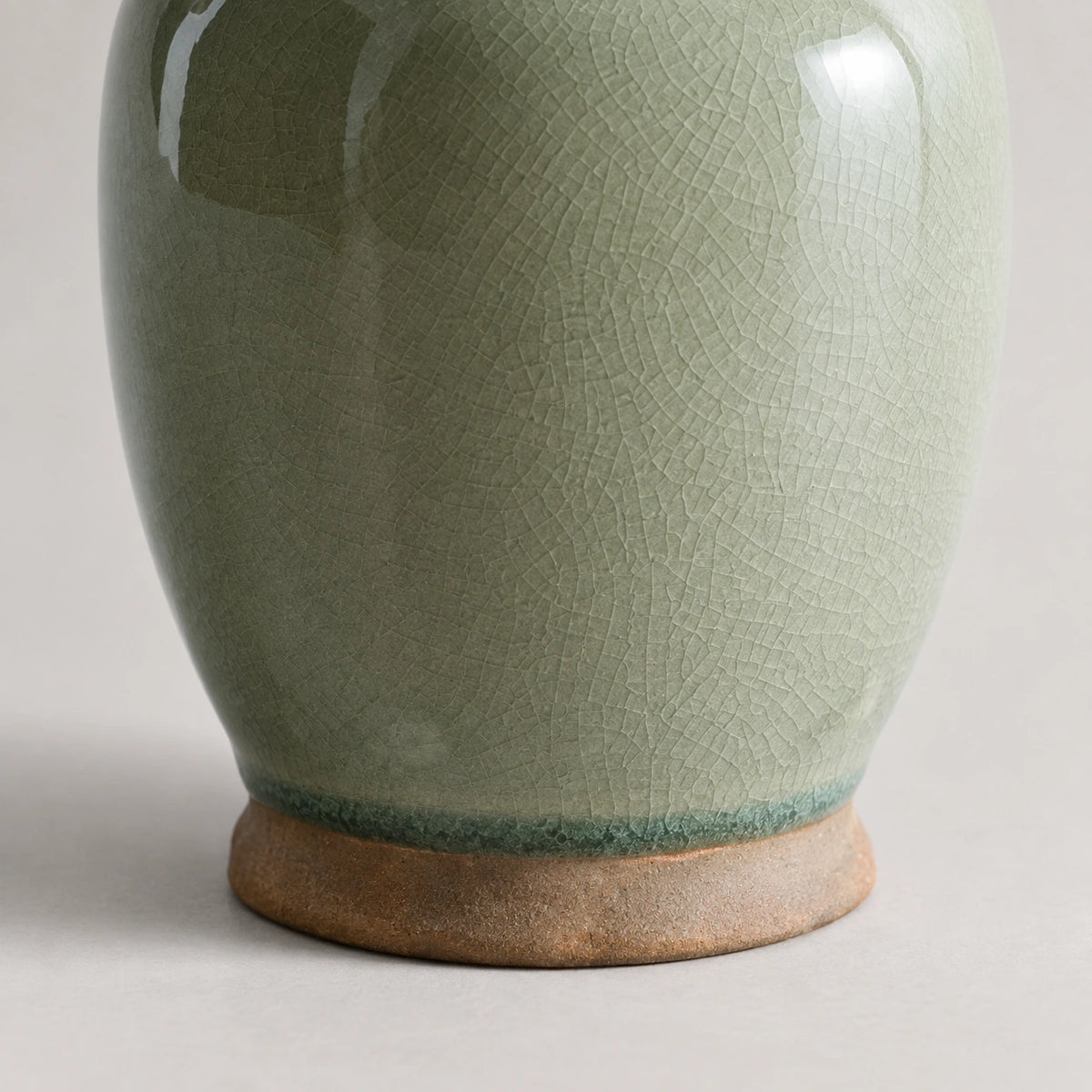 Close-up of the darker green glaze edge and exposed brown ceramic foot of the Willow Sage dispenser.