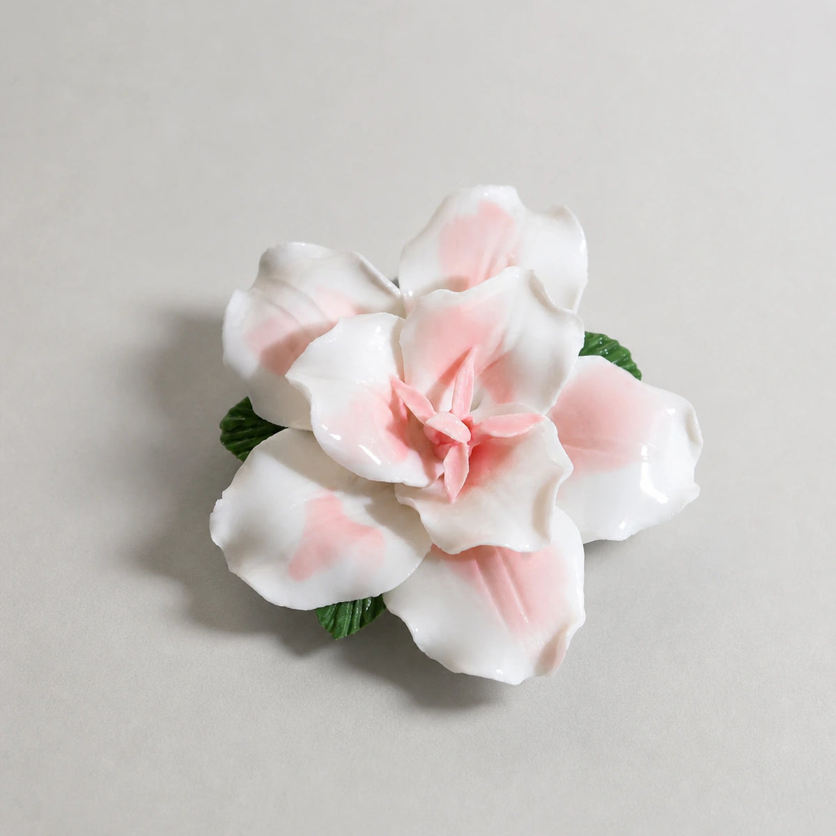 Three-quarter view showing the raised layered petals of a blush pink ceramic lily magnet.