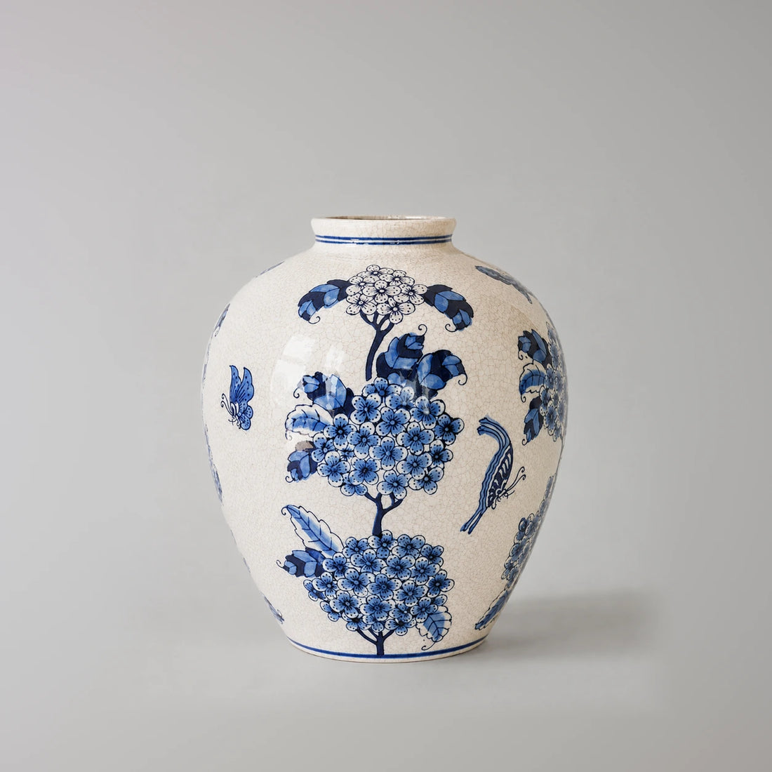 Large blue and white vase with a pale flower cluster near the neck and blue blooms below.