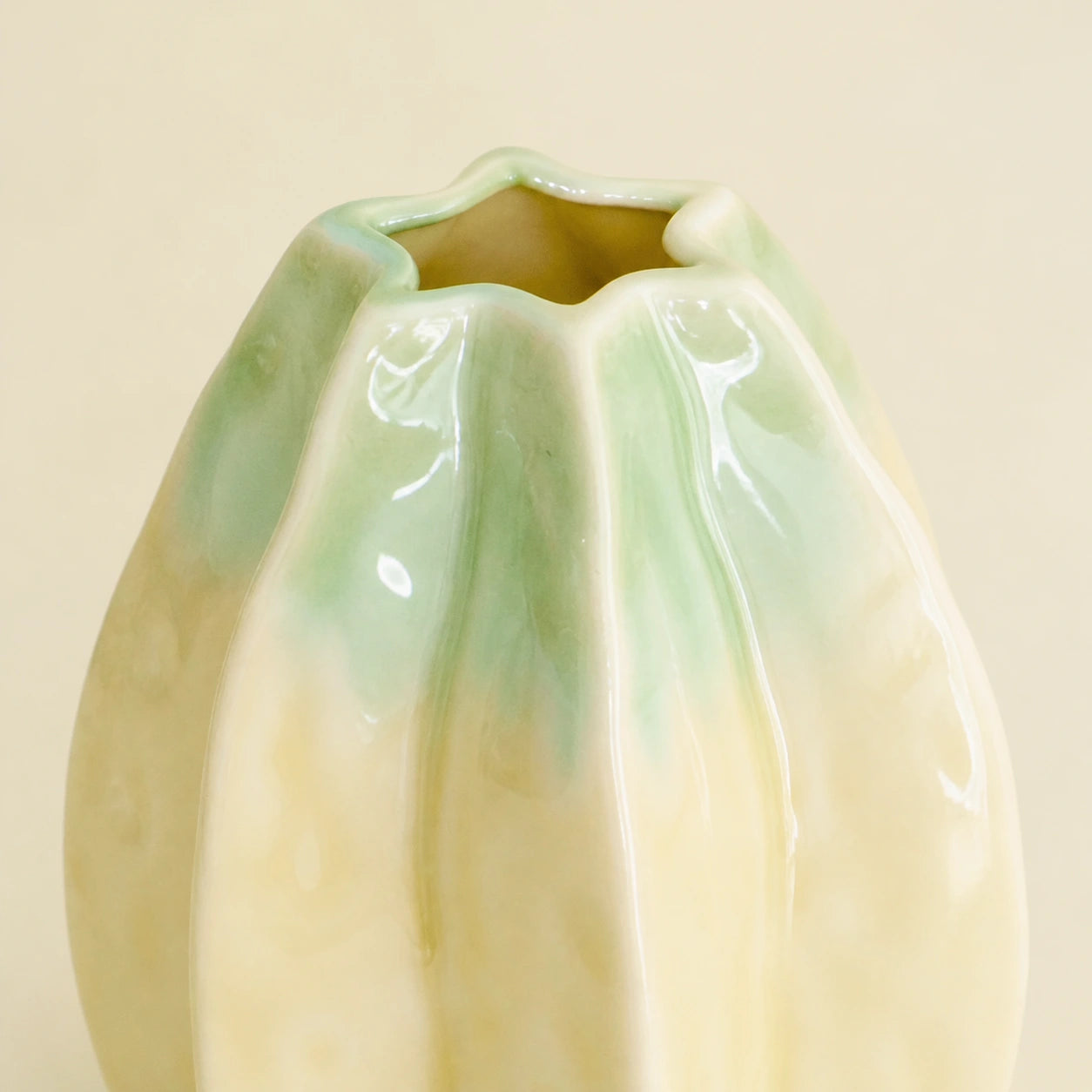 Close view of the Small vase's glossy yellow-green glaze, lobed rim, and opening.