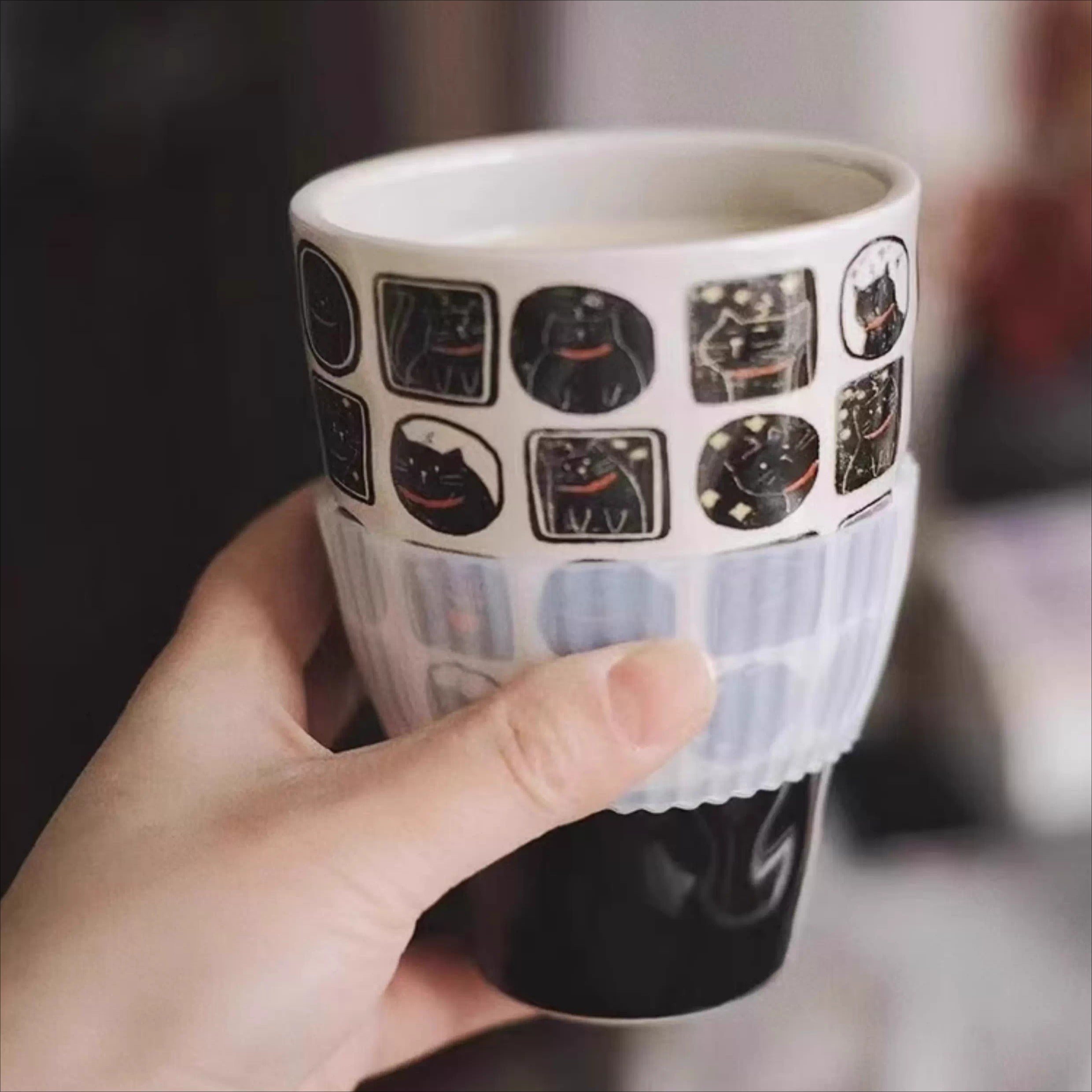 Close-up of nocturnal feline ceramic mug with black cat illustration panels