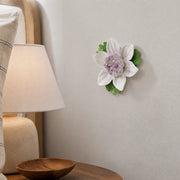Petite fleur de lotus – Accent violet prune, fleur en céramique mise en scène sur un mur intérieur