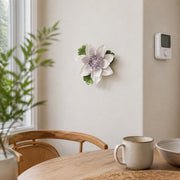 Medium Lotus Bloom Ceramic Wall Flower in Plum Purple Accent mounted beside a plain thermostat in a breakfast nook.