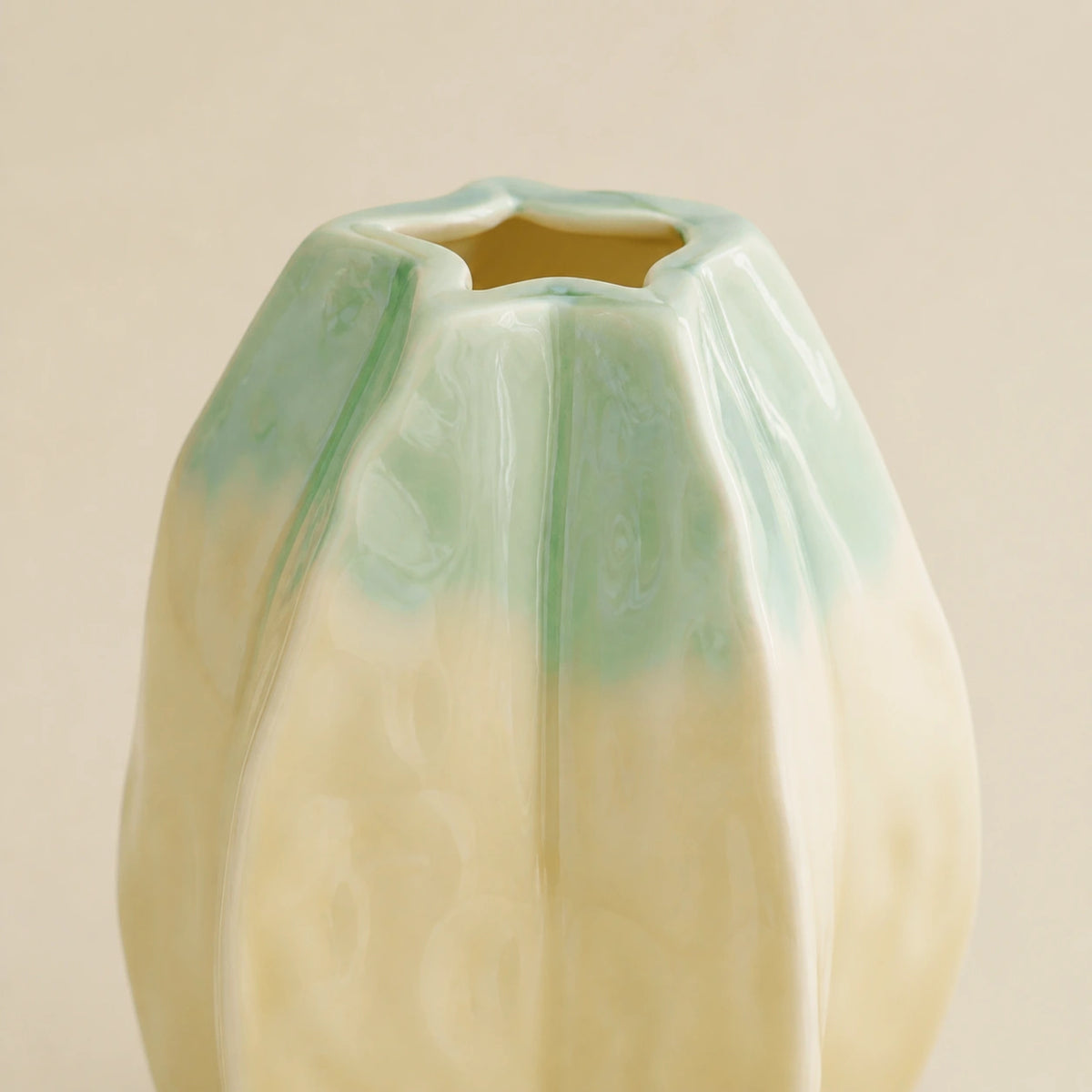 Close view of the Medium vase's glossy yellow-green glaze, elongated lobes, and opening.
