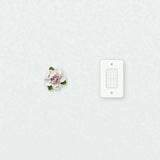 Small Ruffled Peony Ceramic Wall Flower in Plum Purple Accent beside a plain light-switch wall plate for scale.