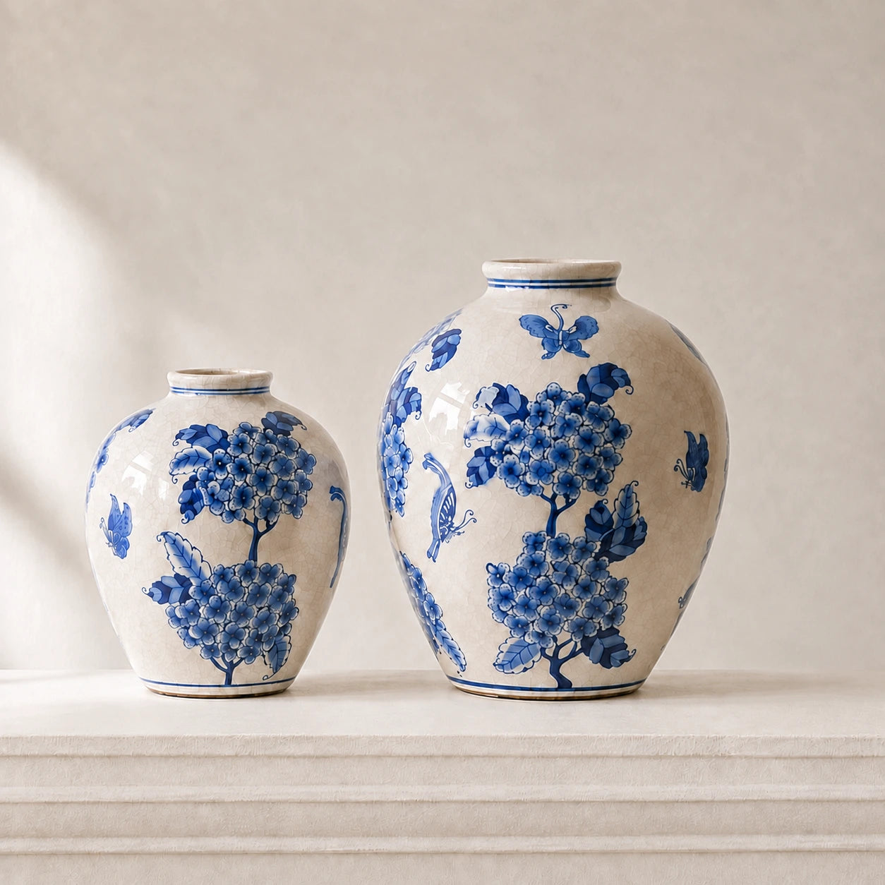Small and large blue and white vases arranged together on a pale plaster mantel.