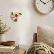 Petite fleur de lotus – Accent rouge rosé, fleur en céramique mise en scène sur un mur intérieur
