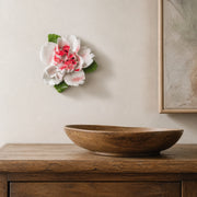 Small Ruffled Peony Ceramic Wall Flower in Rose Red Accent mounted above a low wood bowl on a dining sideboard wall.