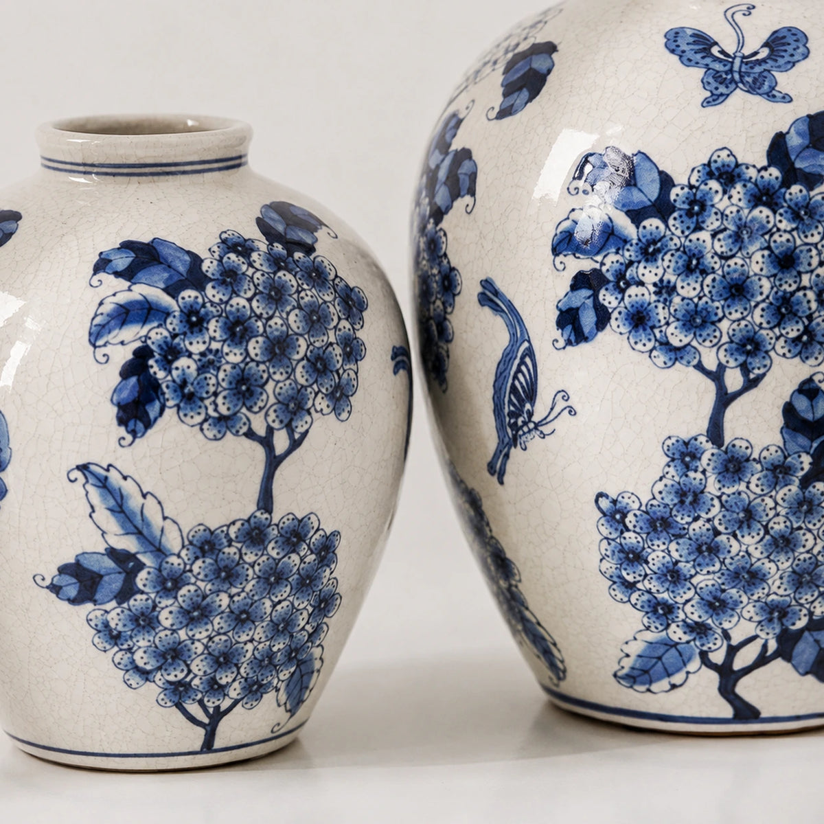 Close-up of blue flower clusters and crackle glaze across the two-vase set.