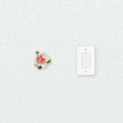 Small Ruffled Peony Ceramic Wall Flower in Rose Red Accent beside a plain light-switch wall plate for scale.