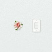 Medium Ruffled Peony Ceramic Wall Flower in Rose Red Accent beside a plain light-switch wall plate for scale.