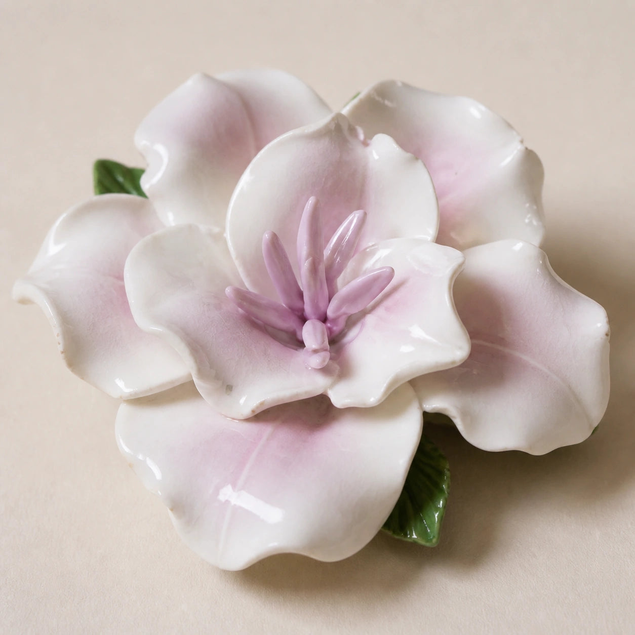 Close view of pale lavender glaze, layered petals and the pointed center of a ceramic lily magnet.