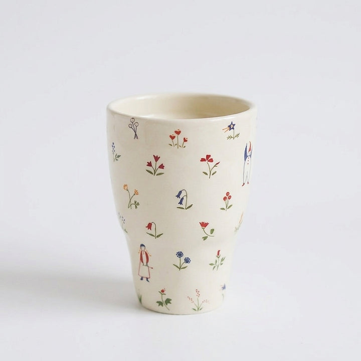 Whimsical folk art ceramic mug with tiny flowers, figures and animal illustrations