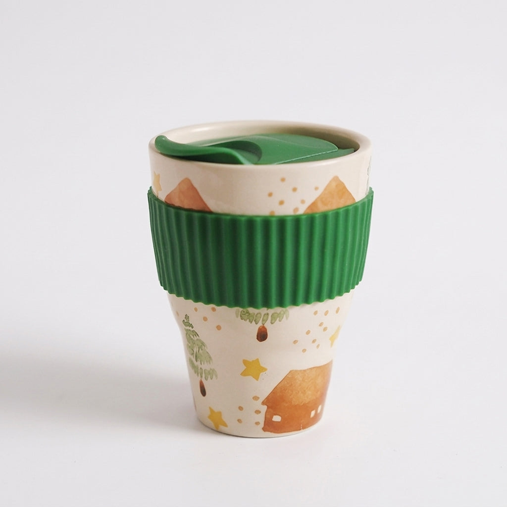 Pastoral folk art ceramic travel mug with green lid and ribbed green sleeve