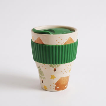 Pastoral folk art ceramic travel mug with green lid and ribbed green sleeve