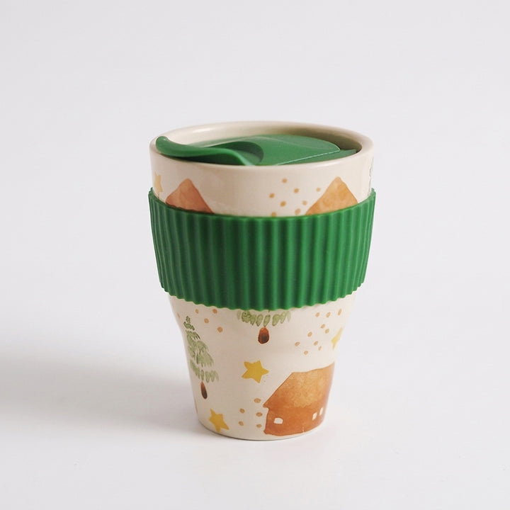 Pastoral folk art ceramic travel mug with green lid and ribbed green sleeve