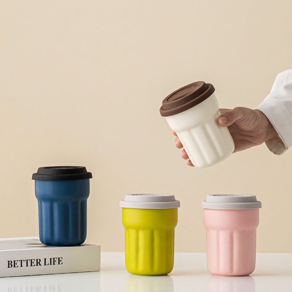 Four fluted ceramic travel mugs in navy, lime, pink and cream with silicone lids