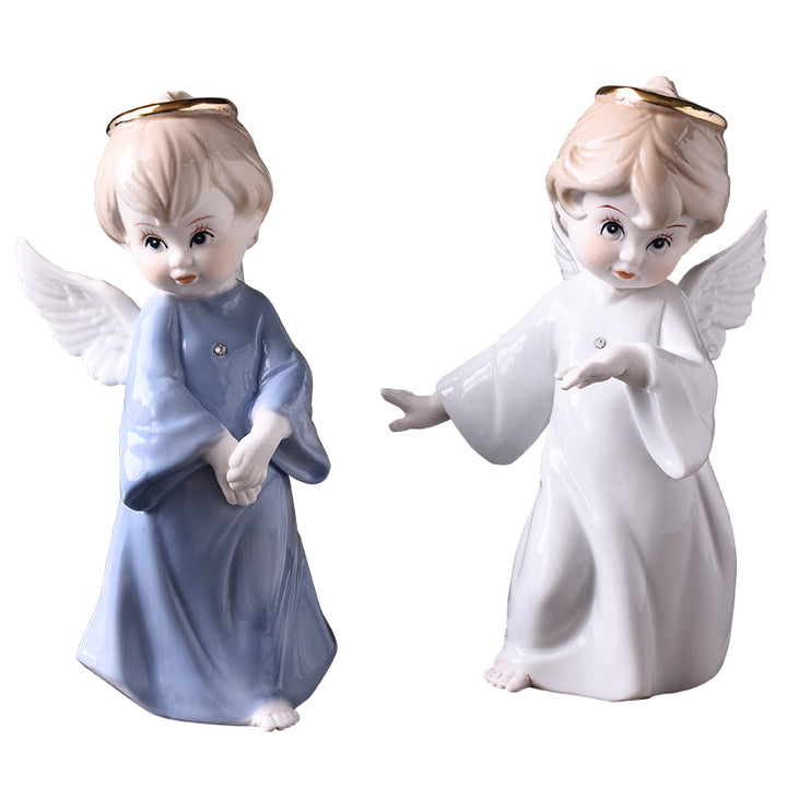 Two porcelain angel figurines against white: left in pale blue with crossed hands, right in white with arms extended.