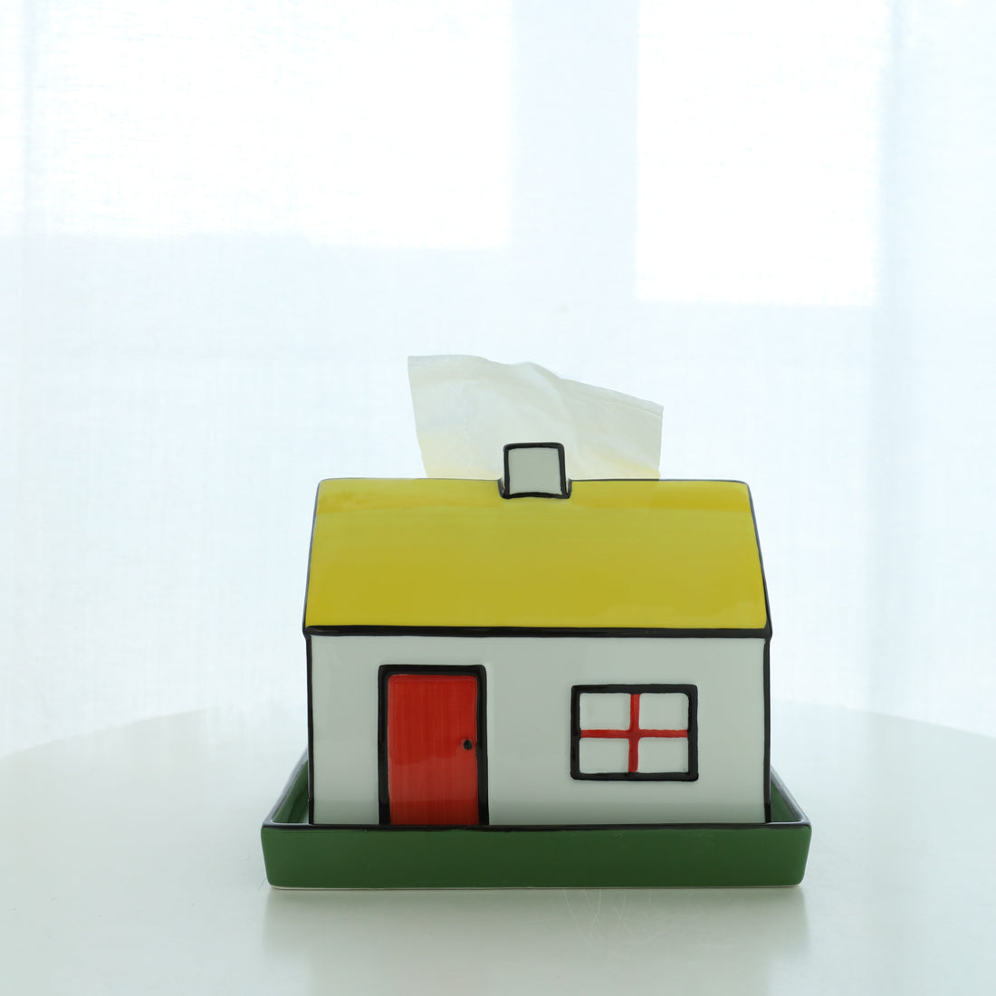 House-shaped tissue box cover with a red door and yellow roof on a white background