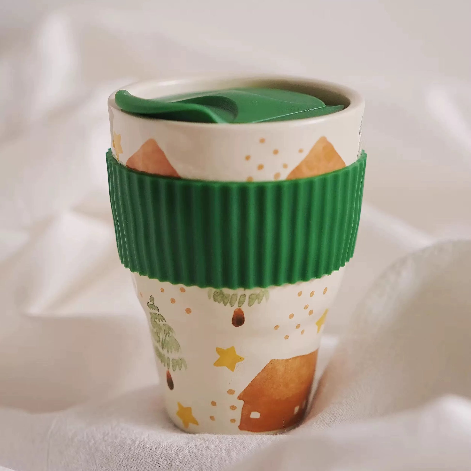 Close-up of green ribbed sleeve and green lid on pastoral folk art ceramic mug