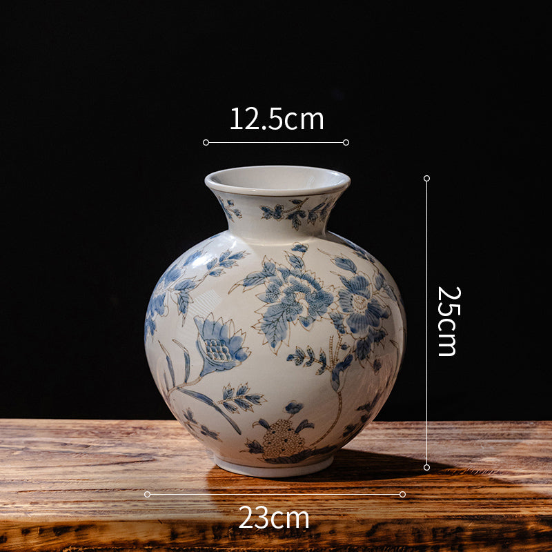 Ceramic vase with blue floral patterns on a wooden surface, shown with measurements.