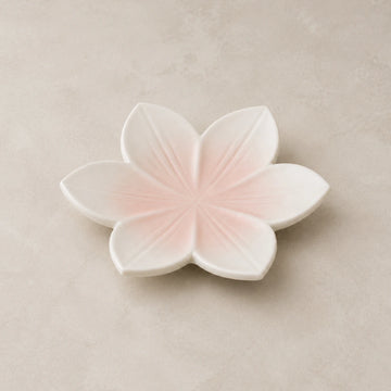 Blushing Sakura ceramic soap dish with six blush-pink petals on a warm neutral background