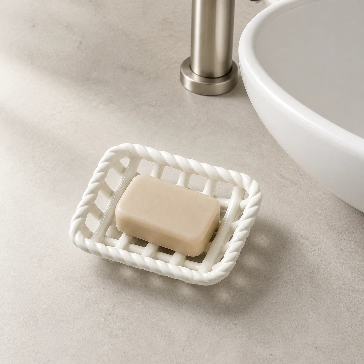 Glossy White ceramic soap basket holding a beige bar beside a bathroom sink