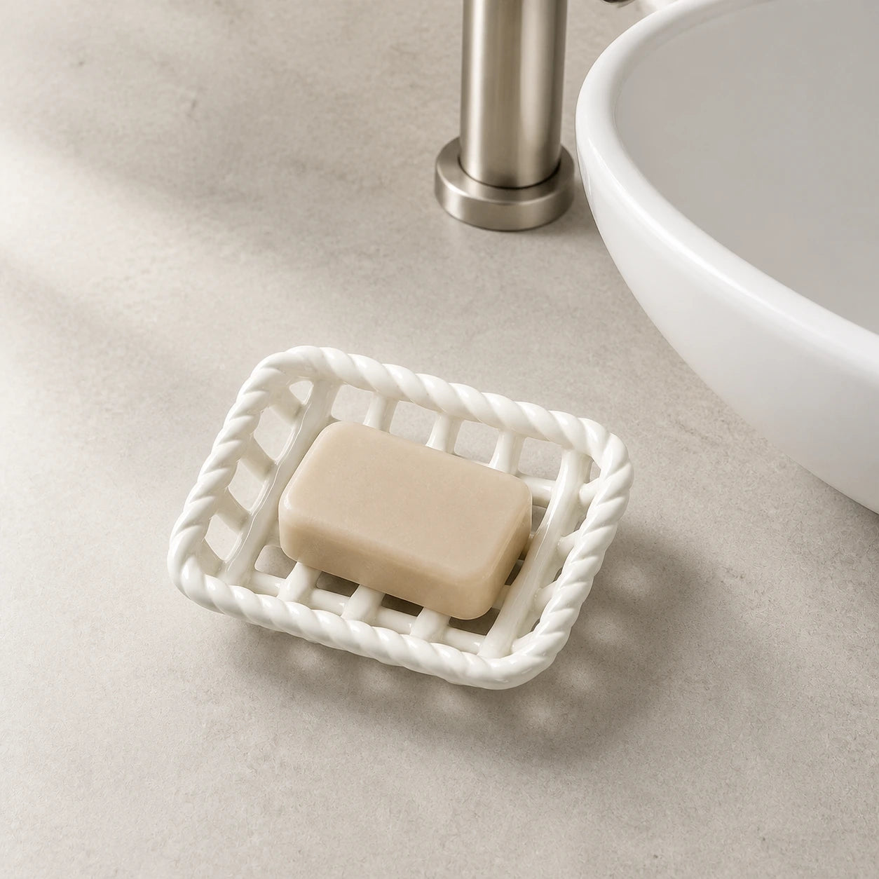 Glossy White ceramic soap basket holding a beige bar beside a bathroom sink