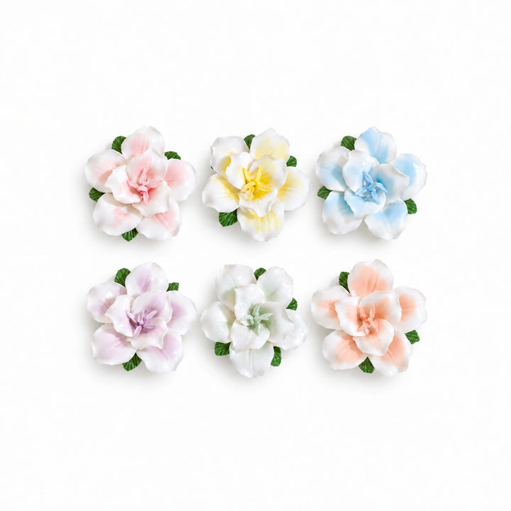 Set of six ceramic lily fridge magnets in pink, yellow, blue, lavender, pale green and soft orange on white.