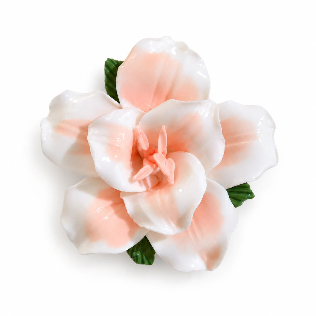 Aimant lys en céramique orange doux, avec des feuilles vertes sur fond blanc.